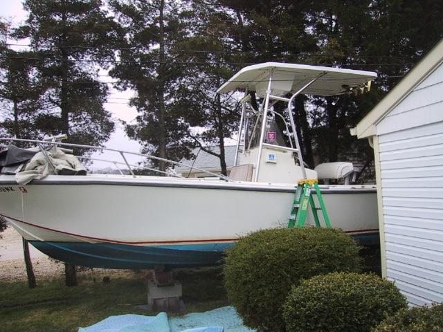 Atlantic Towers T-Top installed on a Mako 23 Inboard boat, positioned beside a house with a ladder nearby.