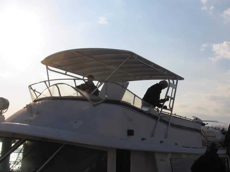 Atlantic Towers Top on a Hatteras 58 MY boat with two individuals working on the upper deck under the canopy.