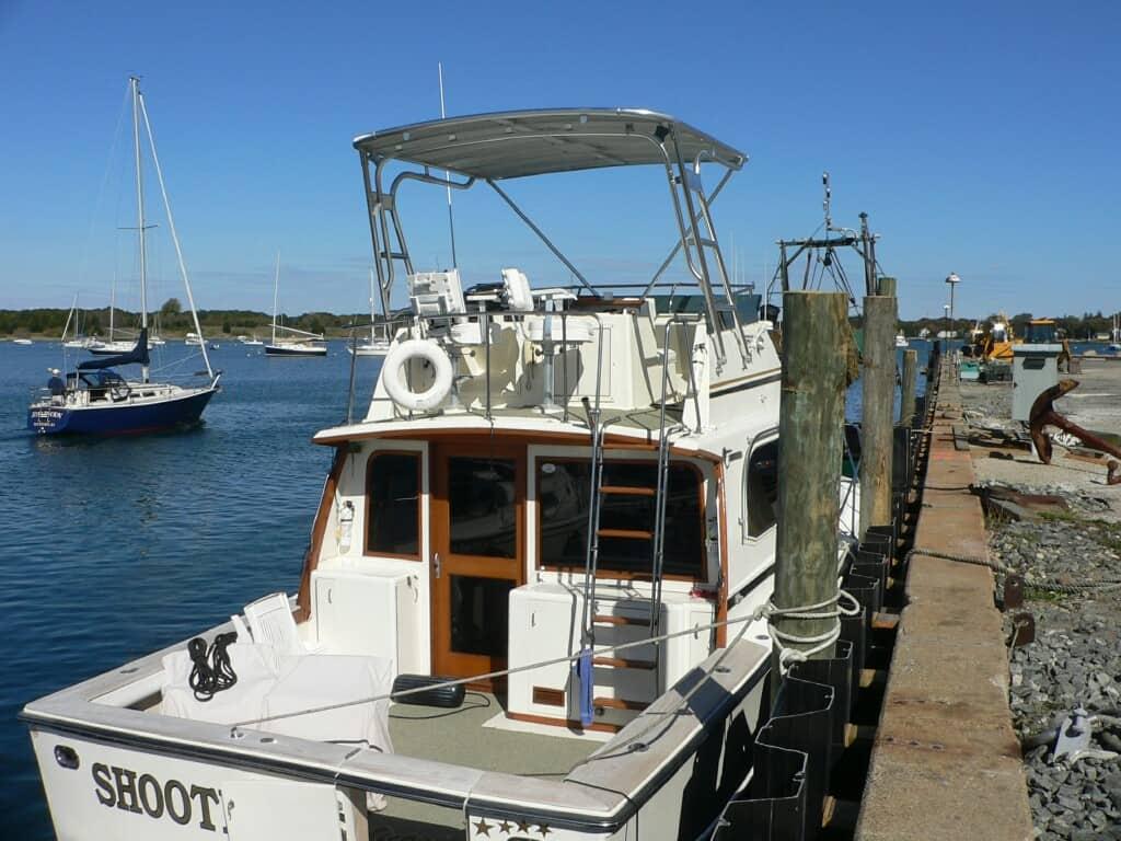 Atlantic Towers Top installed on an Egg Harbor 35 Sport Fisherman boat docked by the water with sailboats in the background.