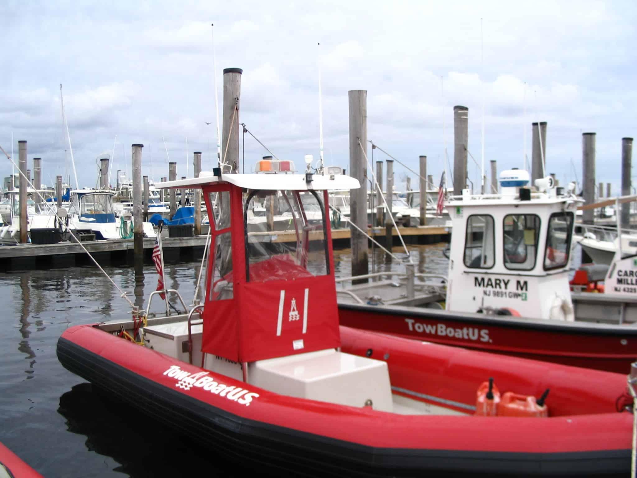 Atlantic Towers T-Top installed on a red Willard Rib boat at a marina with several boats in the background.