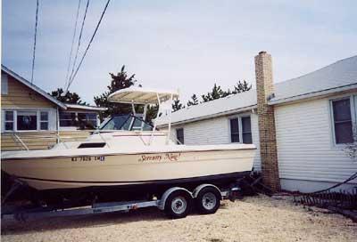 Atlantic Towers Top installed on a Chaparral 224 WA boat, parked next to a house in a residential area.