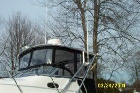 Atlantic Towers Top installed on Angler Boats 2500WA boat with enclosed cabin on a calm lake.