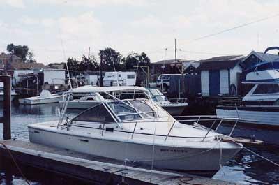 Atlantic Towers Top installed on a Phoenix 27 Weekender boat docked at a marina surrounded by other boats.