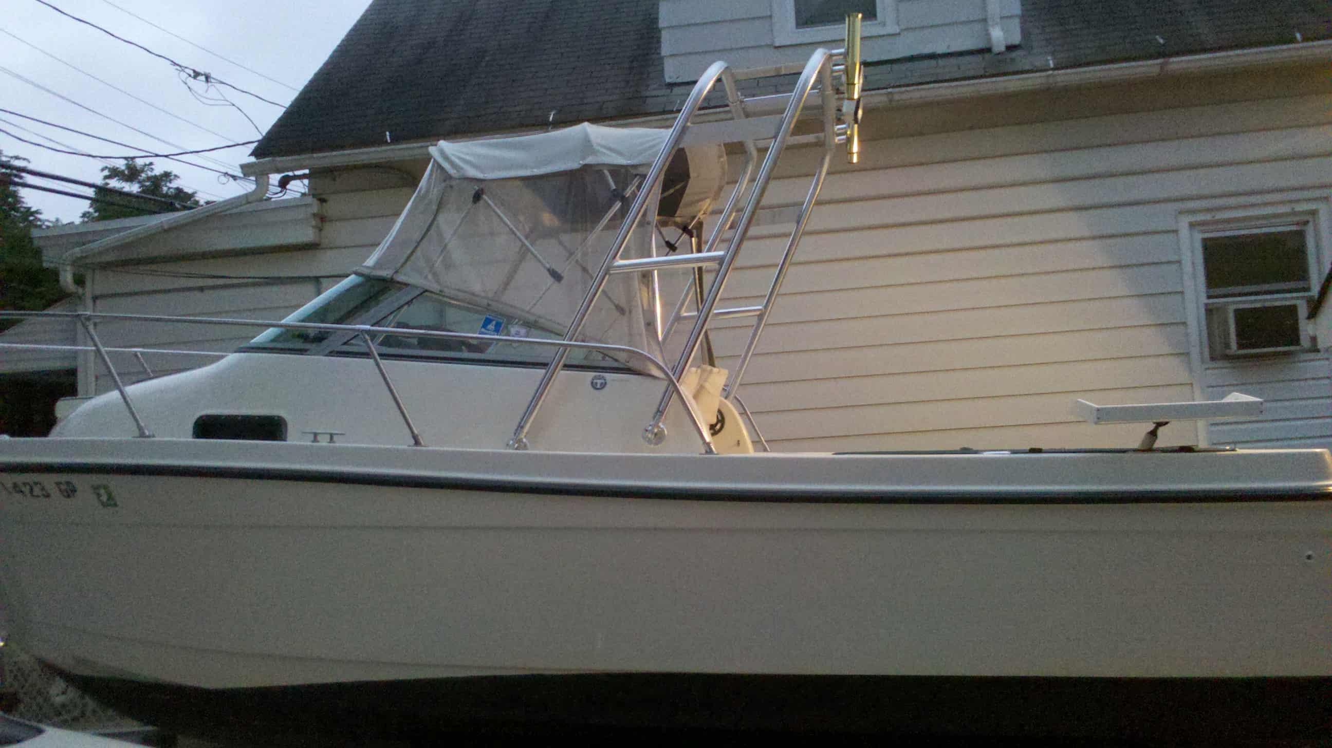 Atlantic Towers Arch installed on a Trophy 2002/2052 boat, positioned beside a house.