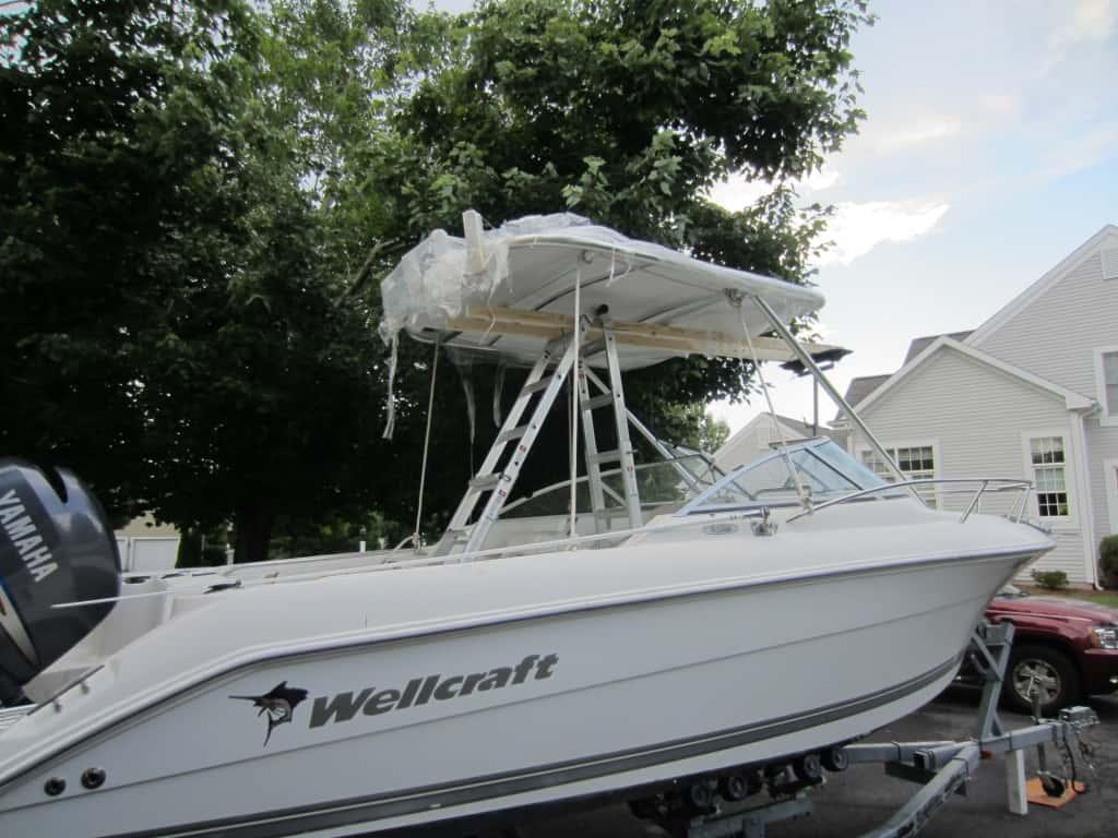 Atlantic Towers Top installed on a Wellcraft V-21 Steplift boat, surrounded by trees and parked near residential buildings.