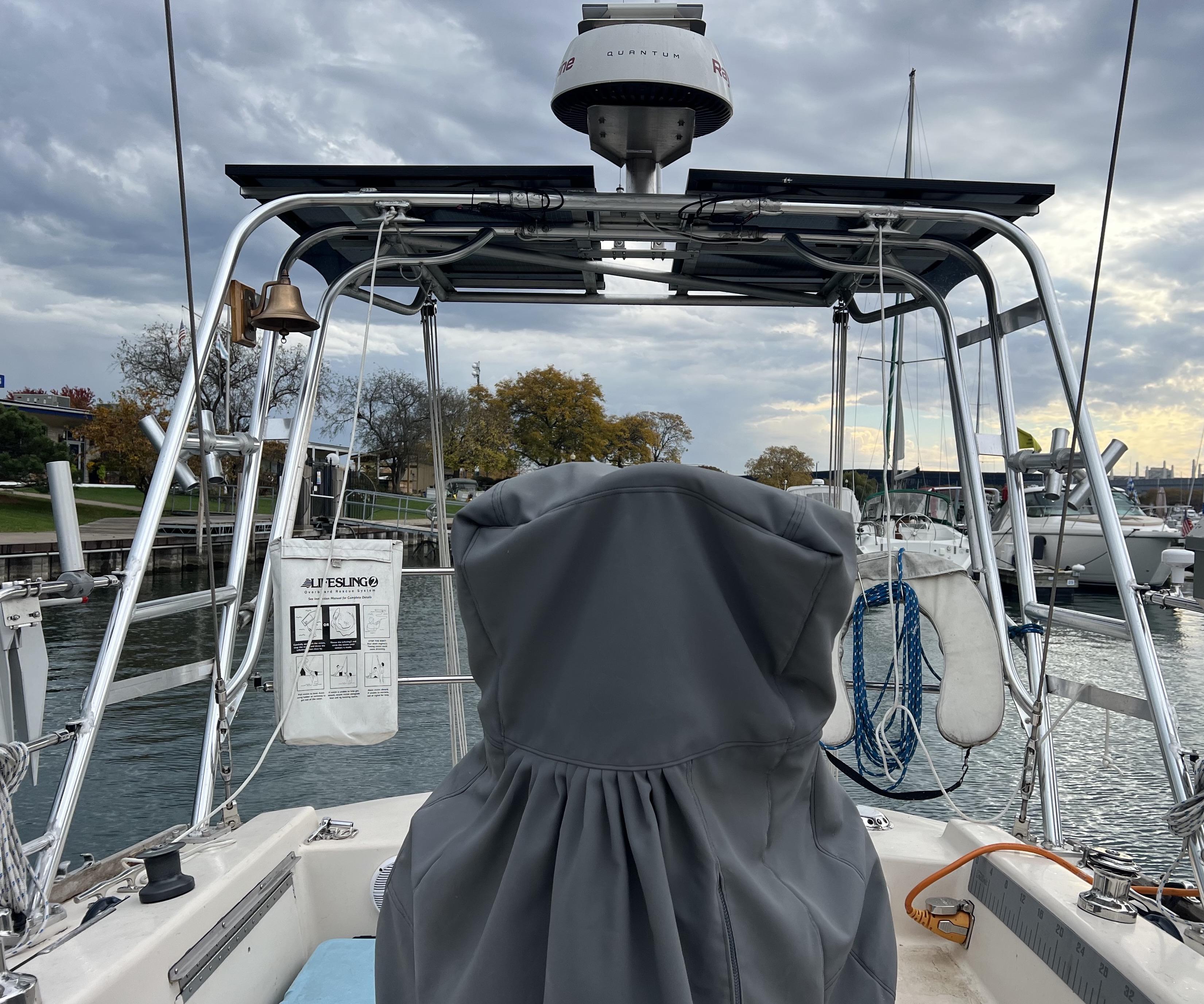View of a boat's cockpit with an Atlantic Towers Arch, a bell, and mooring gear in a marina setting.