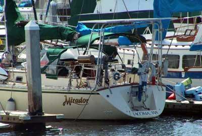 Atlantic Towers Arch installed on a Caliber 40 boat docked at a marina with green canvas covers.