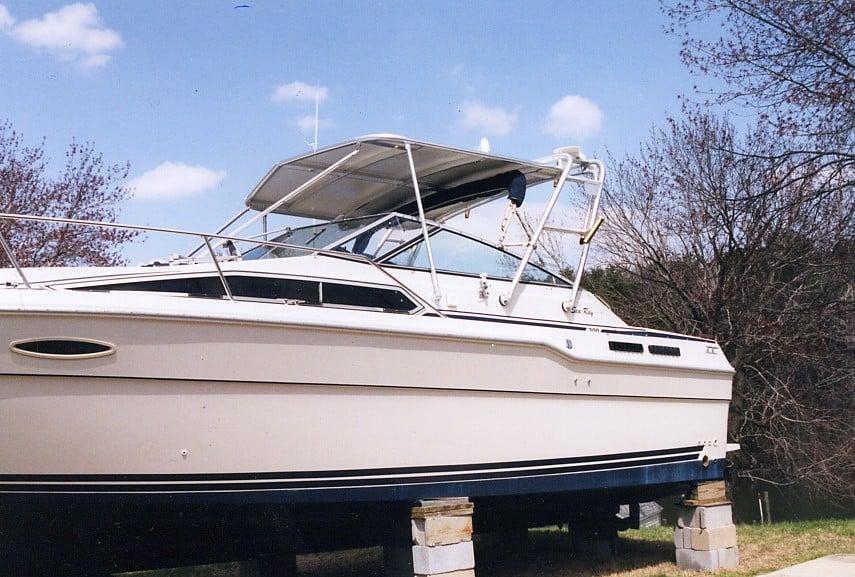 Side view of a Sea Ray 300 Weekender boat on blocks featuring an installed Atlantic Towers Top canopy frame.