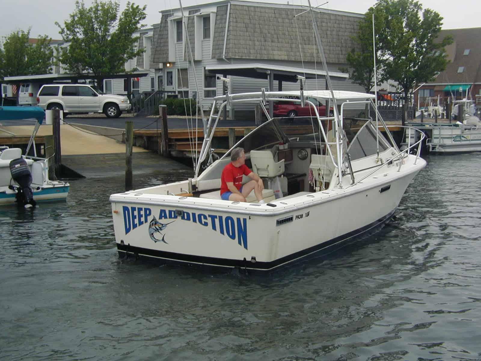 Atlantic Towers Top installed on a Phoenix 27 Weekender boat with a person sitting at the stern near a dock.