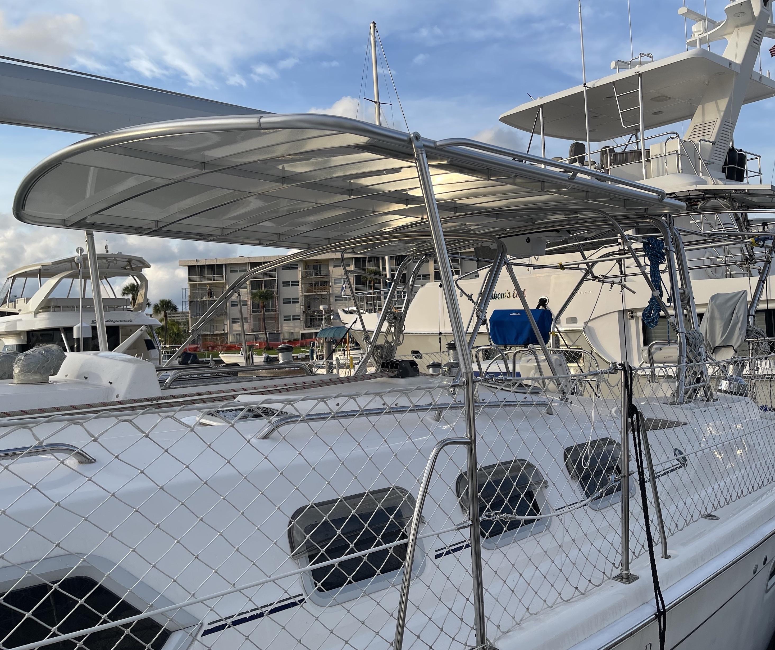 Atlantic Towers Top canopy installed on a sailboat providing shade over the deck with nearby yachts in the marina.