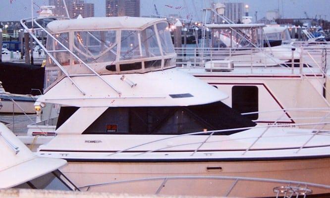 Atlantic Towers arch installed on white Phoenix 37/38 SFX Convertible boat docked in marina with city buildings in background