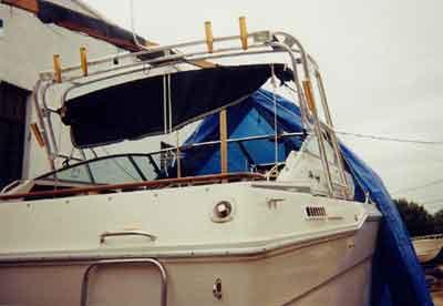 Atlantic Towers Arch installed on the white Sea Ray 300 Sundancer boat with a blue tarp on the deck in a marina.