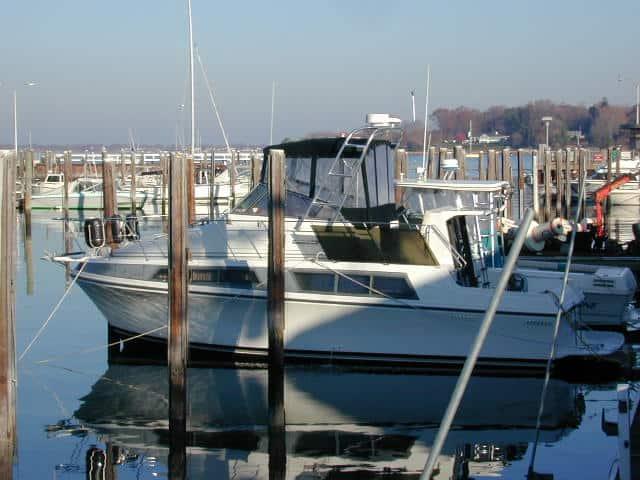 Atlantic Towers arch installed on a Carver 32/330 Mariner boat docked in a marina, reflecting in the water.
