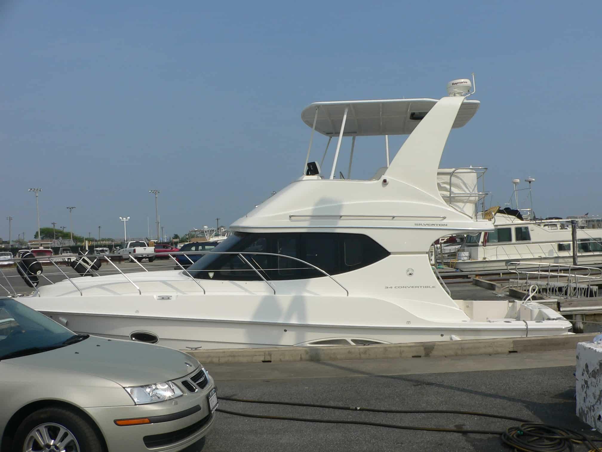 Atlantic Towers Top installed on Silverton 34C/36C white yacht docked beside concrete pier with vehicles nearby.
