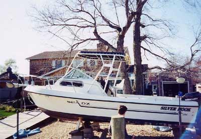 Atlantic Towers Top installed on a Sea Ox 230 boat named Silver Hook, dry docked near trees and a house.