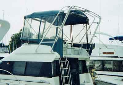 Atlantic Towers arch on a Silverton 37 Convertible boat, featuring a blue bimini top and ladder access.