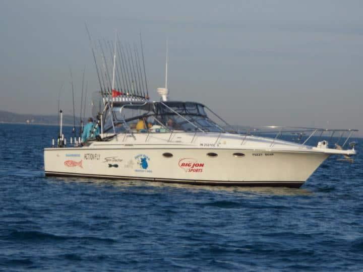 Atlantic Towers Top installed on a Trojan boat, cruising through the water with fishing rods mounted.