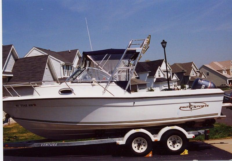 Pro Sport 2200 Walkaround boat on trailer with Atlantic Towers arch installed, parked in a residential neighborhood.
