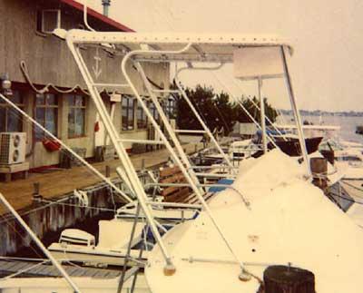 Atlantic Towers Top installed on Bertram 25 Flybridge boat docked near a waterfront building with other boats nearby.