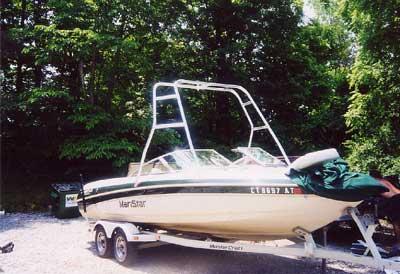 Alt text: Atlantic Towers Air Tower installed on a Mastercraft boat, model 225/230, parked near lush greenery.