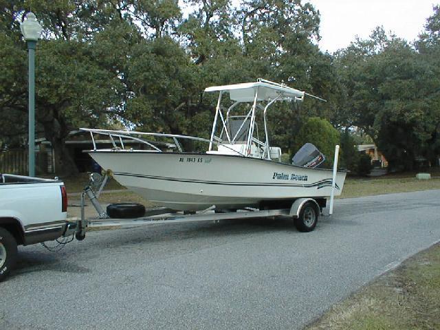 Palm Beach boat with Atlantic Towers T-Top on trailer hitched to a white pickup truck on a residential street