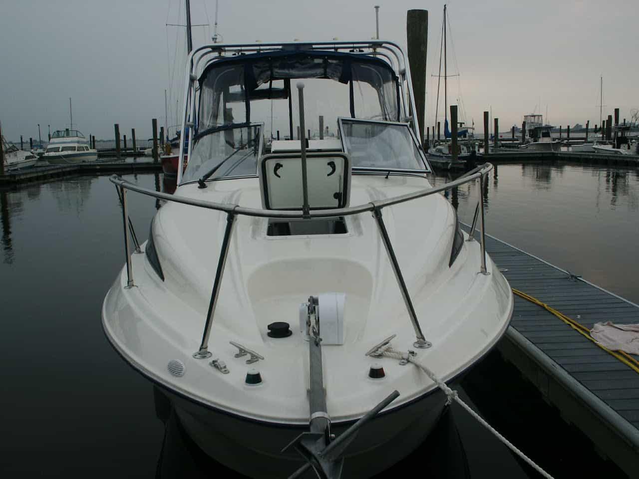 Atlantic Towers Arch installed on a Glacier Bay 2640 Renegade boat at a marina, with calm water and moored boats in the background.