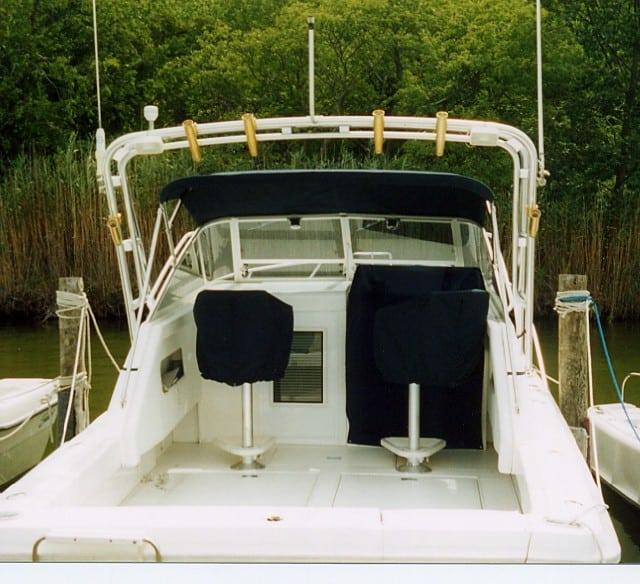 Atlantic Towers Arch installed on Phoenix 27 Tournament II boat with covered seats docked by a green shoreline