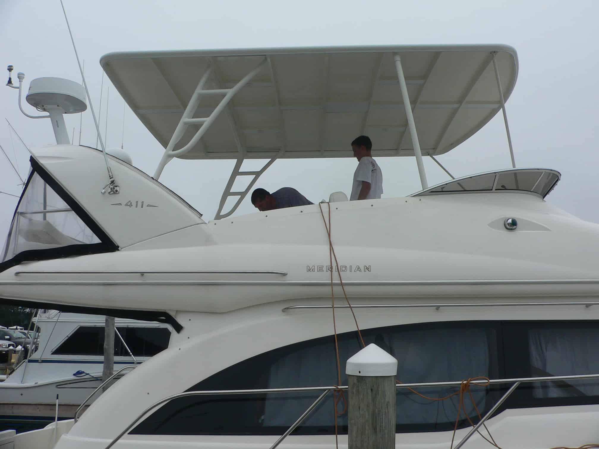 Atlantic Towers Top installed on a Meridian 411 Sedan boat, with two men preparing on the upper deck.