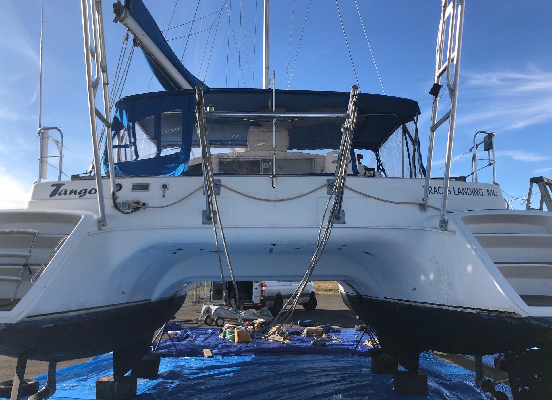 Rear view of a Fountaine Pajot catamaran equipped with an Atlantic Towers Arch, on dry dock with maintenance equipment underneath.