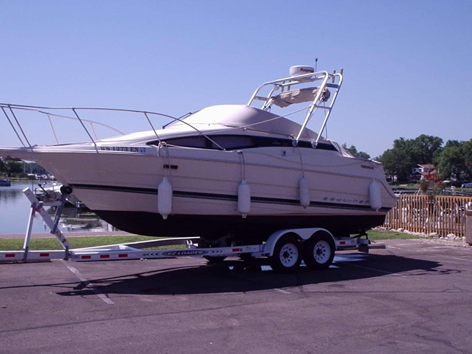 Atlantic Towers arch installed on a Bayliner 2655 Ciera Sunbridge boat on a trailer by the water.