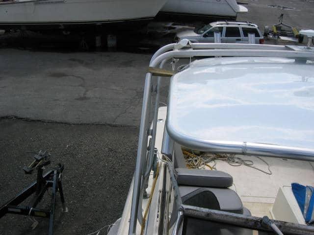 Atlantic Towers Top installed on the bow of a Phoenix 27 Weekender boat parked on a trailer in a marina lot.