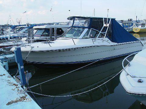 Atlantic Towers Top installed on a Pursuit 2460 Denali boat docked in a marina, reflecting the surrounding water.