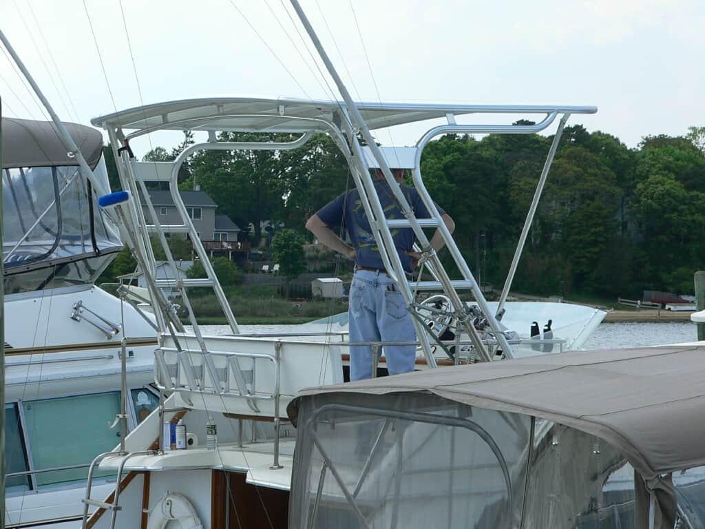 Atlantic Towers Top installed on Chris Craft 30 Tournament boat with man standing at the helm in a marina setting