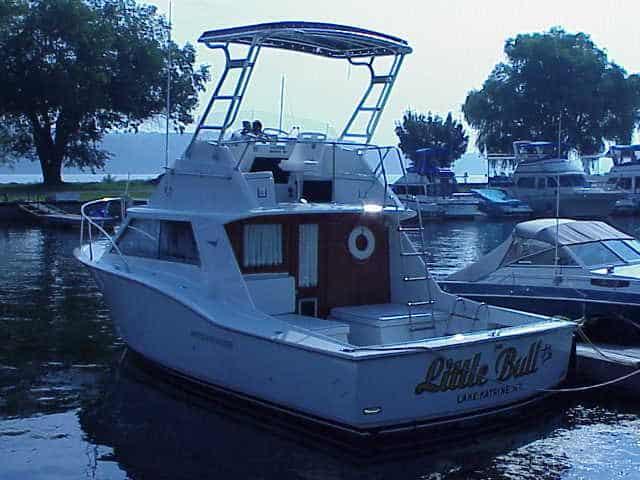 Atlantic Towers Top installed on a Hatteras 36 Convertible boat docked in a marina with trees and other boats in the background.