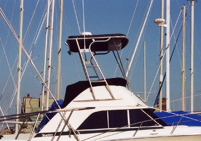 Atlantic Towers Top installed on a Silverton 31 Convertible boat at a marina, surrounded by masts and sails.