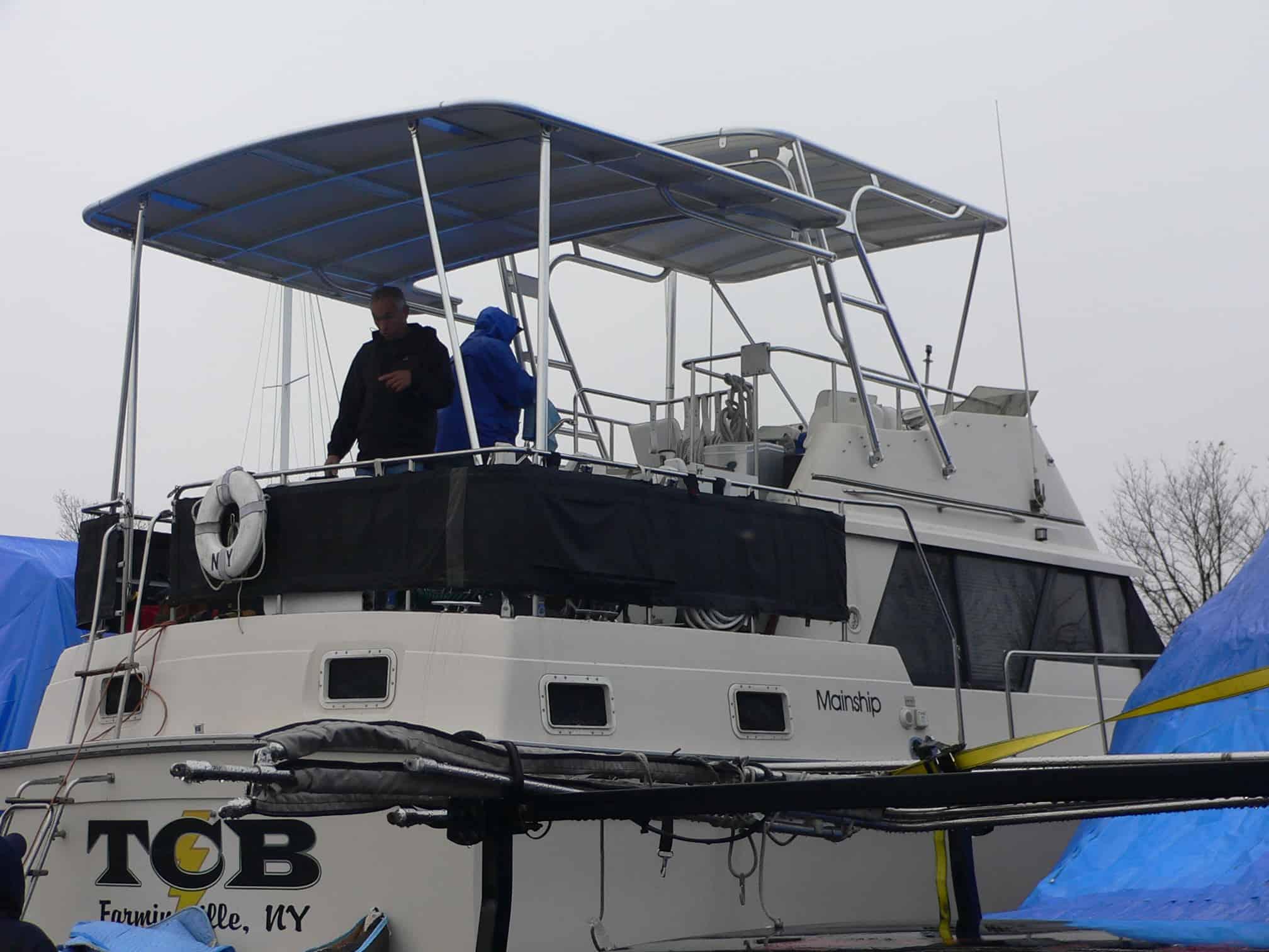 Atlantic Towers Aft Deck Top installed on a Mainship 36 Double Cabin boat with two people on the aft deck.