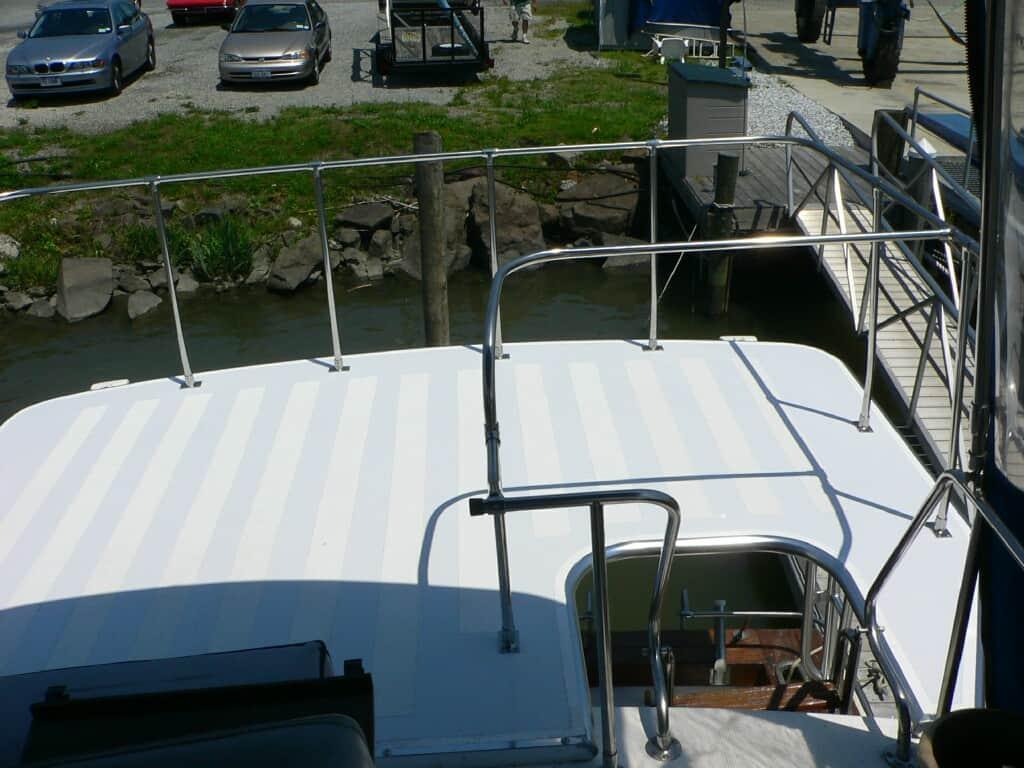 Atlantic Towers Cockpit Sun Shade installed on the Pequod 34 Sedan boat, showing white deck and metal railings at dock.