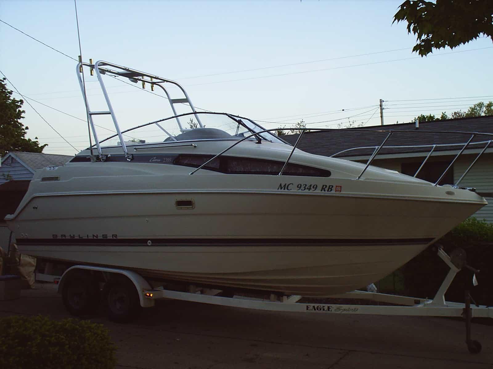 Atlantic Towers Arch installed on a Bayliner 2355 Cierra boat, parked on a trailer in a residential area.