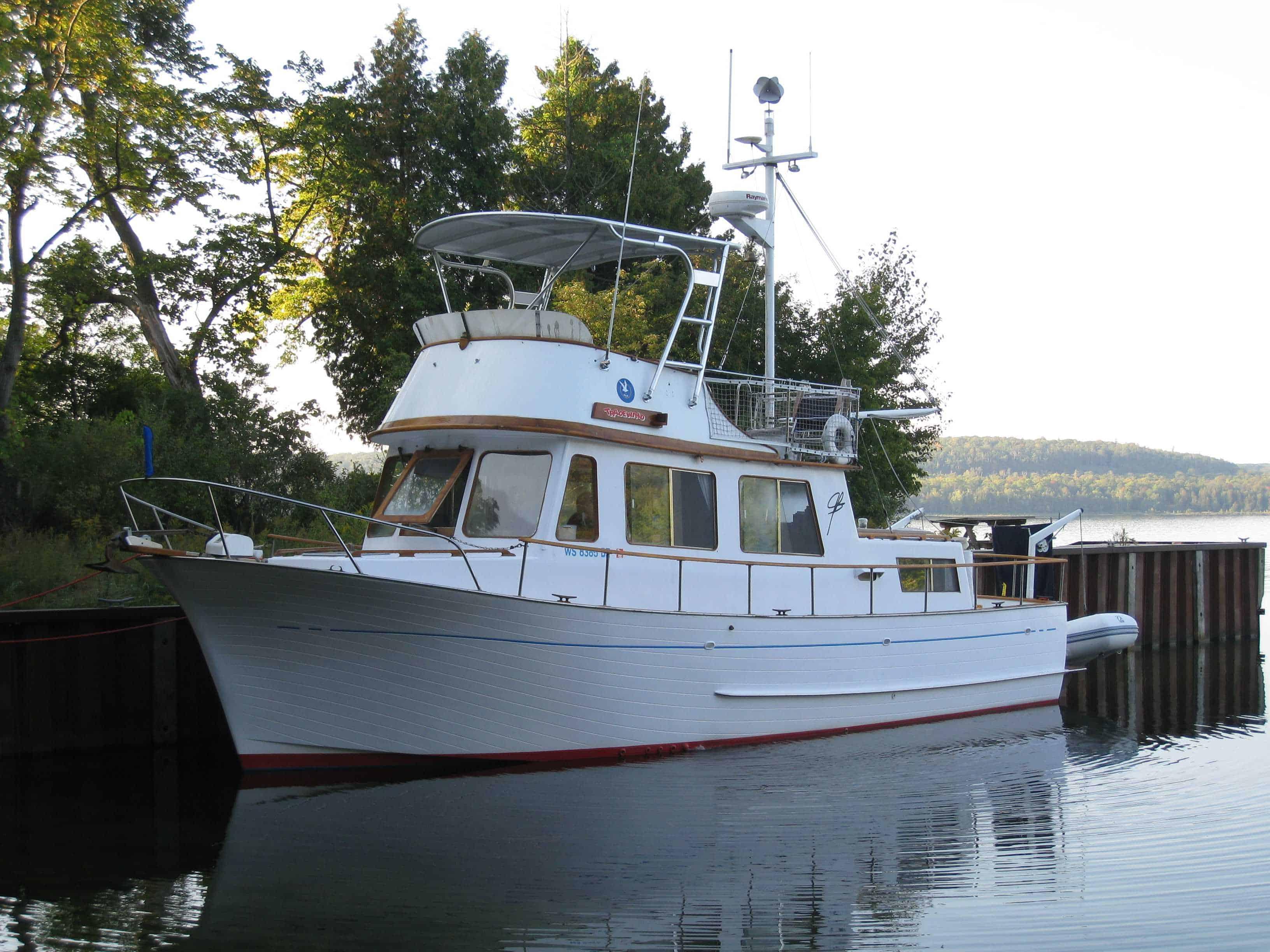 Atlantic Towers Top installed on a Marine Trader 34 Trawler, docked near trees reflecting in the water.