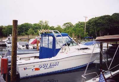 Wellcraft 2600 Coastal boat named Out East with Atlantic Towers Arch docked at a marina with other boats nearby.