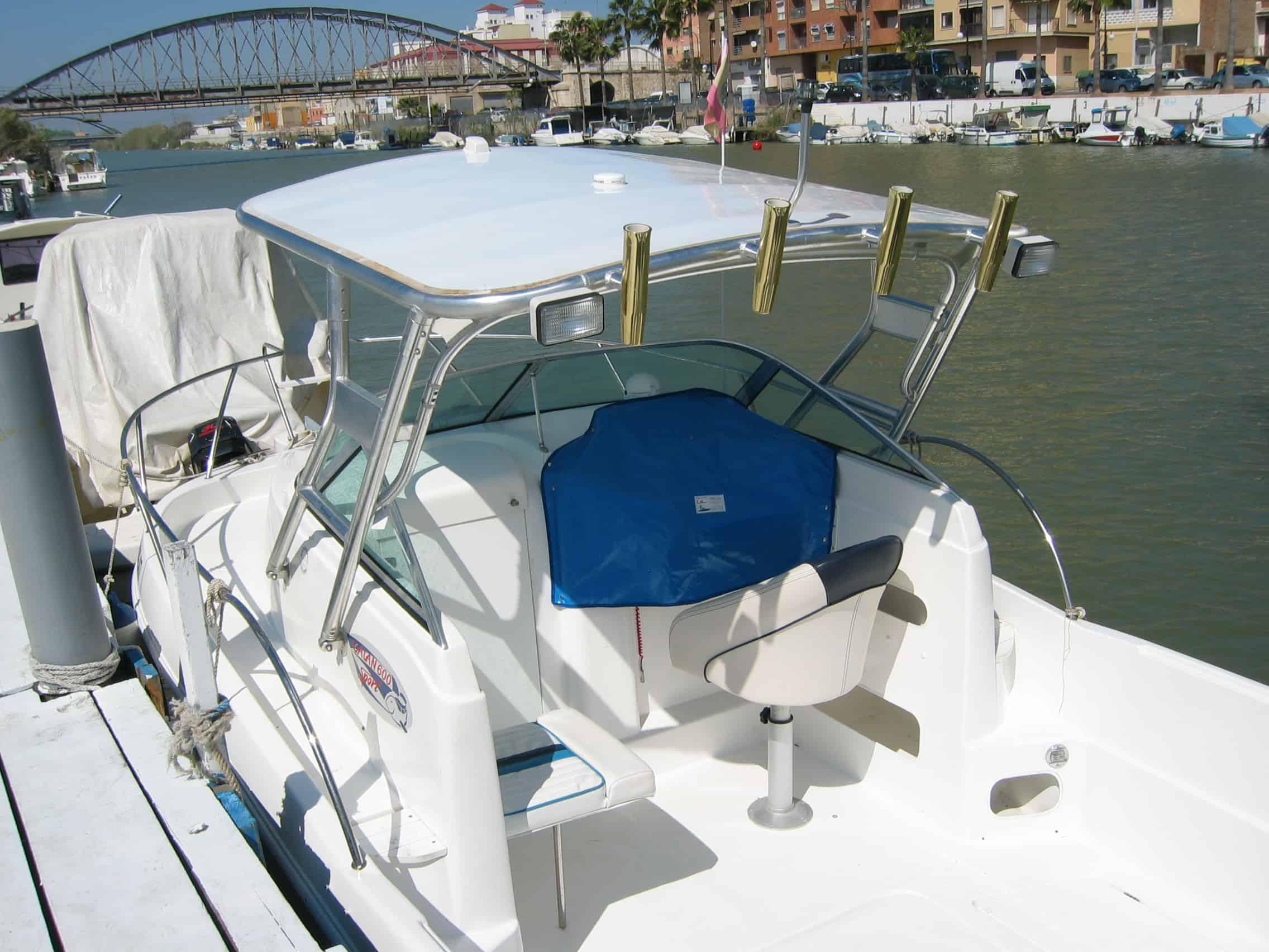 Atlantic Towers Top installed on a boat, featuring seating and fishing rod holders by the water.