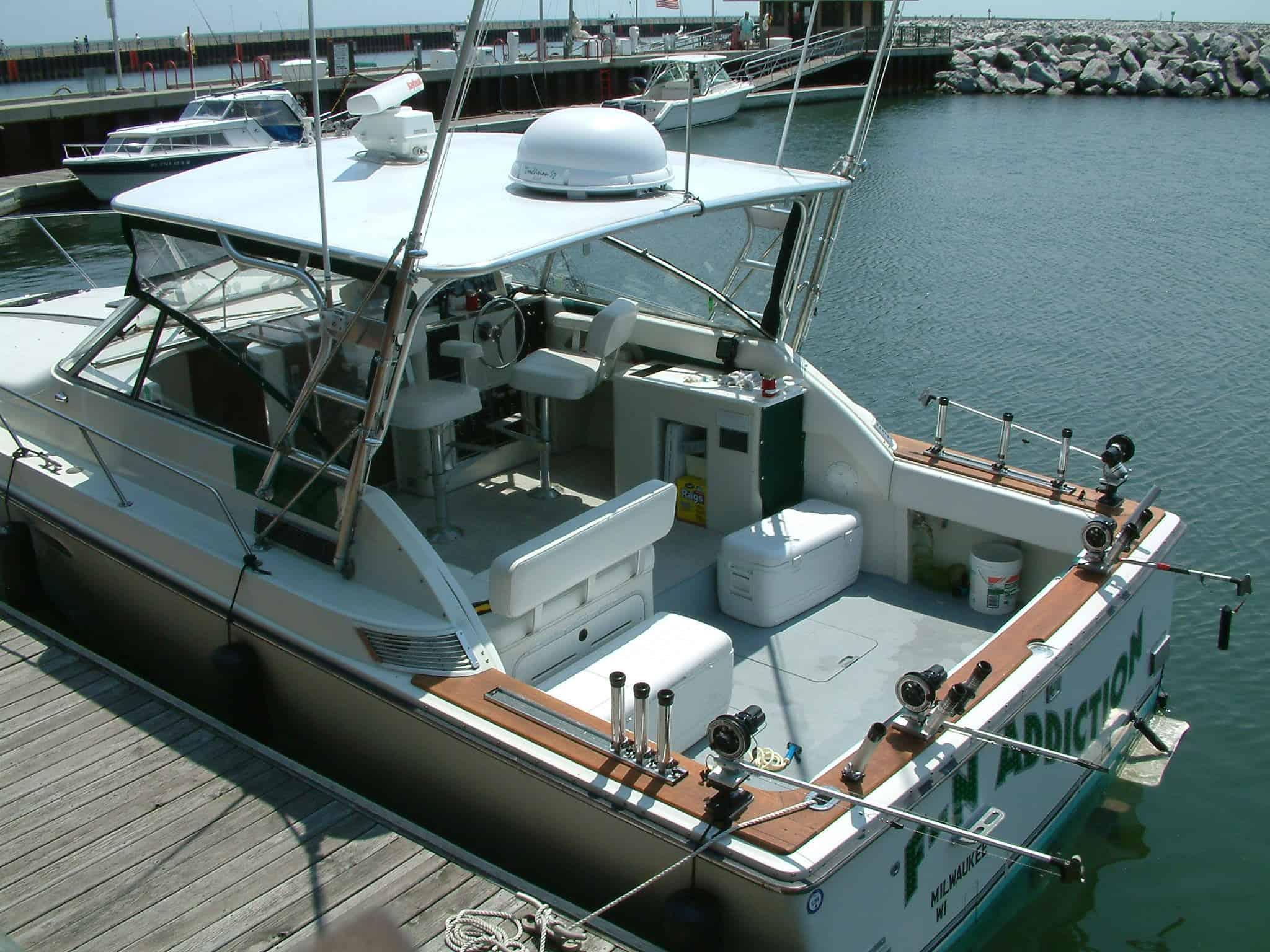 Trojan 10 Meter Express boat docked with Atlantic Towers Top installed, equipped for fishing with rods and electronic devices.
