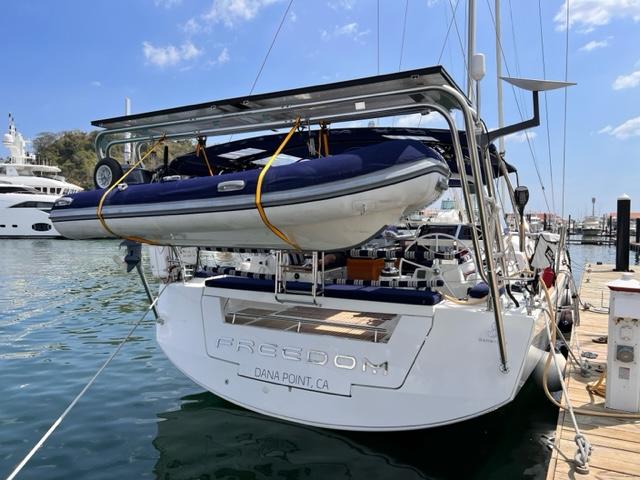 Atlantic Towers Arch mounted on a boat, supporting a dinghy above the stern, docked in a marina.