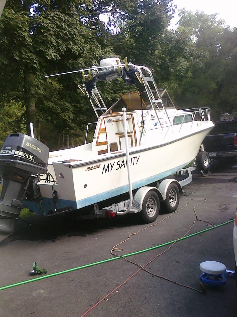 Atlantic Towers Arch installed on a white Mako 238 Walkaround boat named My Sanity, on a trailer near trees and vehicles