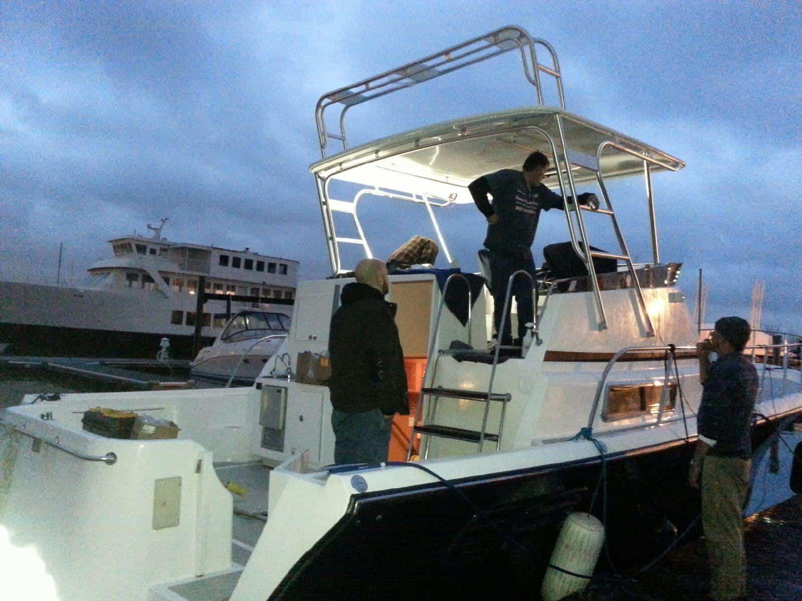 Albin boat docked at marina during dusk with people standing and Atlantic Towers Top installed over the cabin area