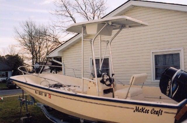Atlantic Towers T-Top installed on a McKee Craft console boat parked outside a house.