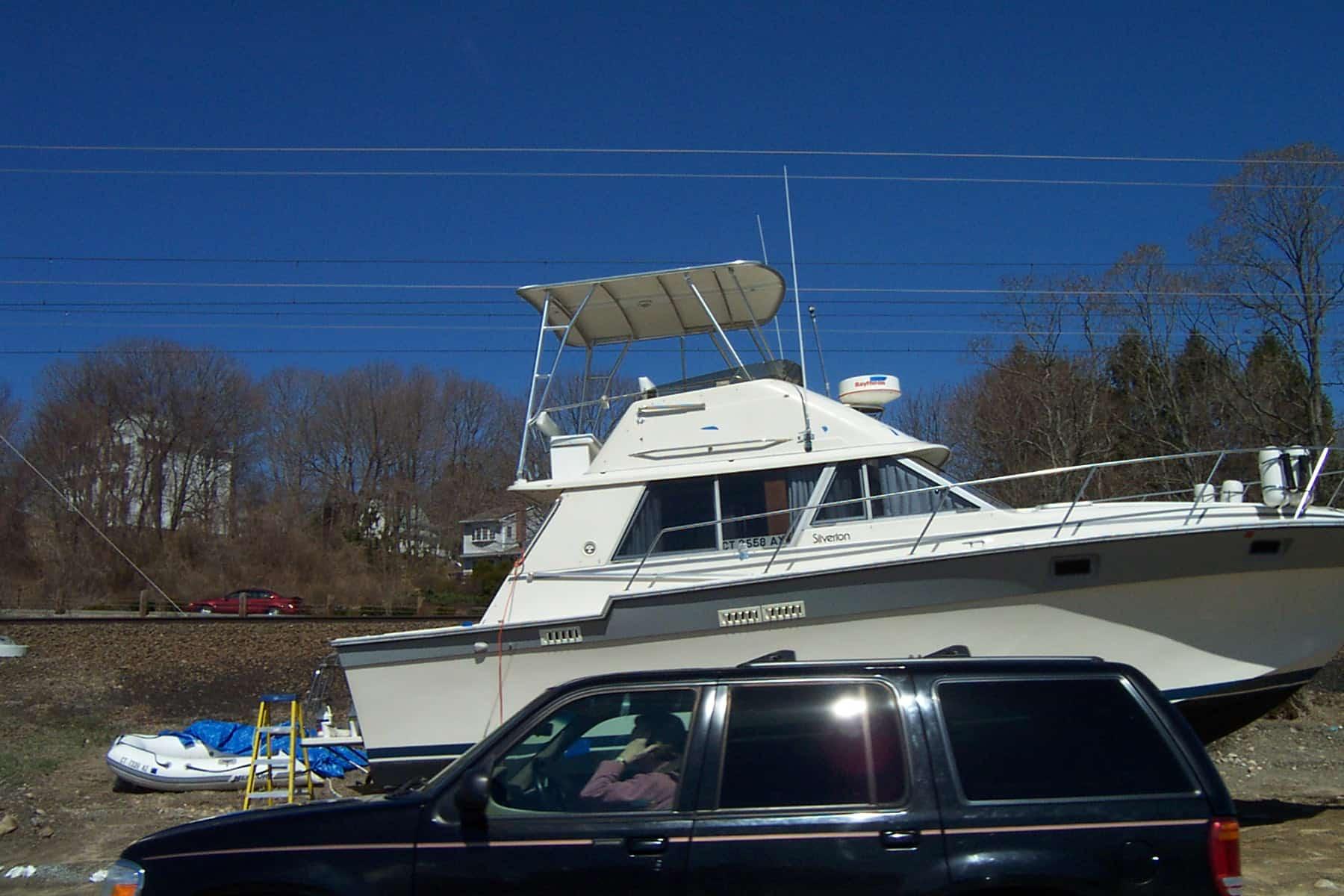Silverton 34 Convertible boat with Atlantic Towers Top installed docked on land next to a black SUV under a clear blue sky