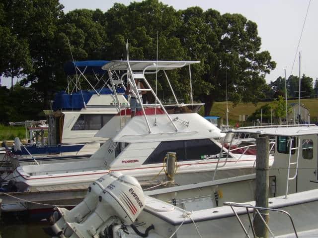 Atlantic Towers Top installed on a Phoenix 29SFX convertible boat docked in a marina.
