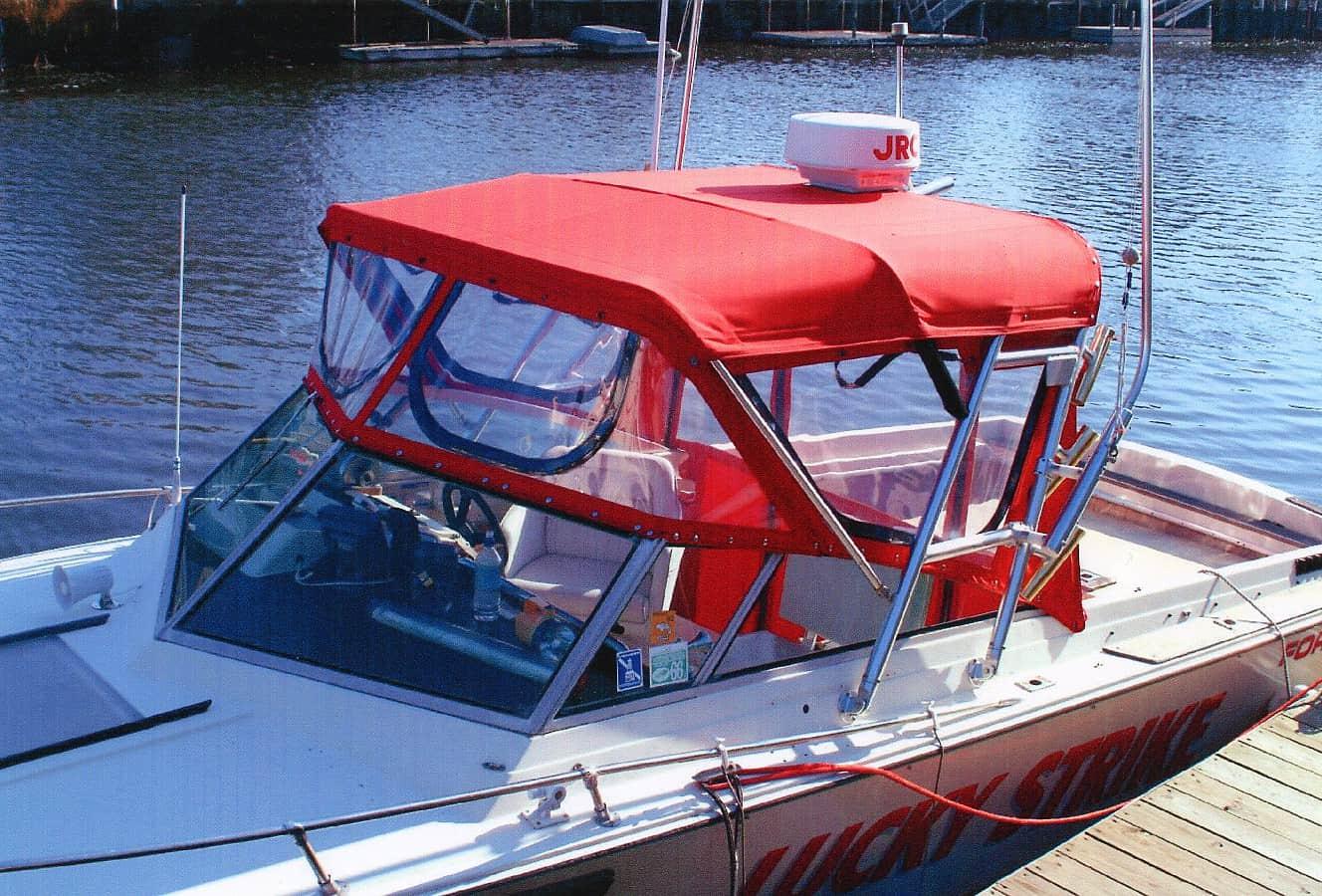 Formula Thunderbird 233 boat docked with a red Atlantic Towers Arch installed and a red canopy covering the cockpit.