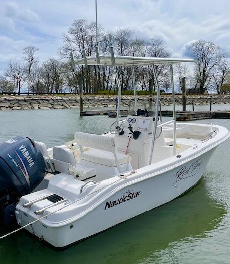 Atlantic Towers T-Top installed on a Nautic Star boat, docked in a calm waterway with trees in the background.